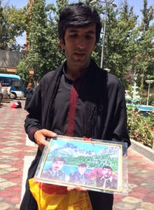 Muhammad Saber holds a photo in Kabul, Aug. 11, 2014, showing his brothers, who were killed in a U.S. and Afghan forces raid on his home in Paktia province