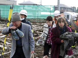 Residents walk through destruction in Sendai