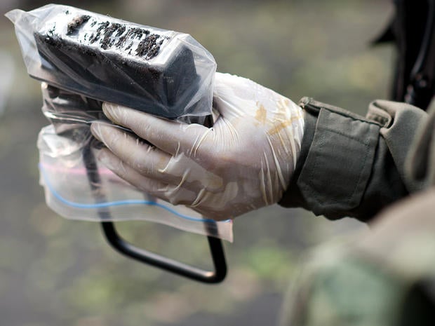 A Thai bomb squad official inspecting the site of an explosion holds a magnet with shrapnel pieces in Bangkok Feb. 14, 2012. Three minor blasts rattled the Thai capital of Bangkok, leaving a foreigner seriously wounded when a grenade he was suspected of carrying exploded, police said.