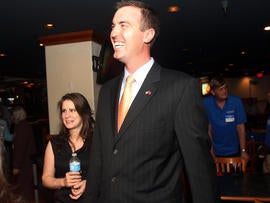 Republican Jesse Kelly, center, smiles as he waits for special election primary results for southern Arizona's 8th Congressional District with his wife, Aubrey Kelly, at the Viscount Suite Hotel in Tucson, Ariz., April 17, 2012.
