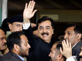 Pakistani Prime Minister Yousuf Raza Gilani, center, waves upon his arrival at the Supreme Court for a hearing in Islamabad, Pakistan, April 26, 2012.