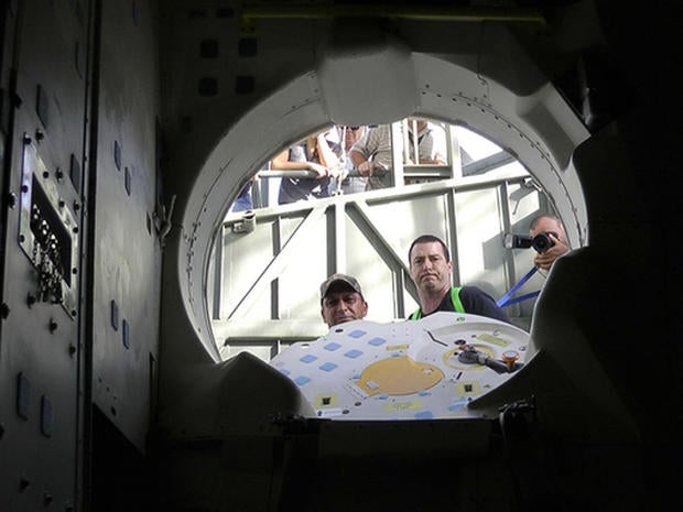 Patch-eye view: NASA techs look into space shuttle Endeavour's crew cabin after storing patches and a photo on board for the orbiterâs final ferry flight.