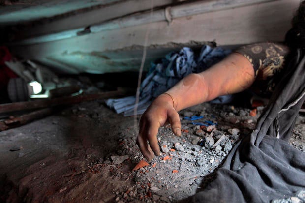 A victim's body trapped in rubble after an eight-story building collapsed