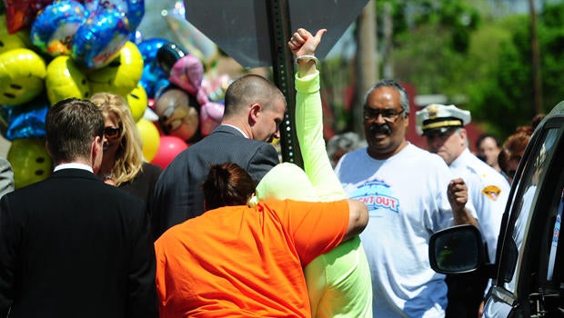 Gina DeJesus raises her thumb as she arrives at her family house on May 8, 2013 in Cleveland, Ohio. DeJesus along with two other women were rescued this week after a decade spent imprisoned and tormented in a kidnapper's house made an emotional return to their families on Wednesday. At right is Gina's father Felix.