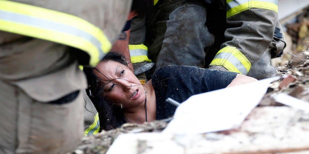 A woman is pulled out from under tornado debris at the Plaza Towers School in Moore, Okla., Monday, May 20, 2013. A tornado as much as a mile (1.6 kilometers) wide with winds up to 200 mph (320 kph) roared through the Oklahoma City suburbs Monday, flattening entire neighborhoods, setting buildings on fire and landing a direct blow on an elementary school.