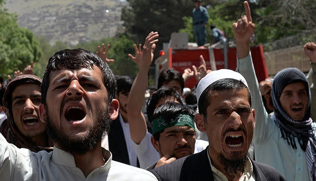 Afghan men chant slogans as they demonstrate against the Elimination of Violence Against Women law