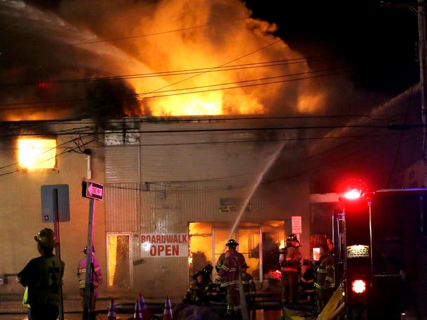 Firefighters battle a blaze in a building on the Seaside Park boardwalk on Thursday, Sept. 12, 2013, in Seaside Park, N.J. The fire began in a frozen custard stand on the Seaside Park section of the boardwalk and quickly spread north into neighboring Seaside Heights.