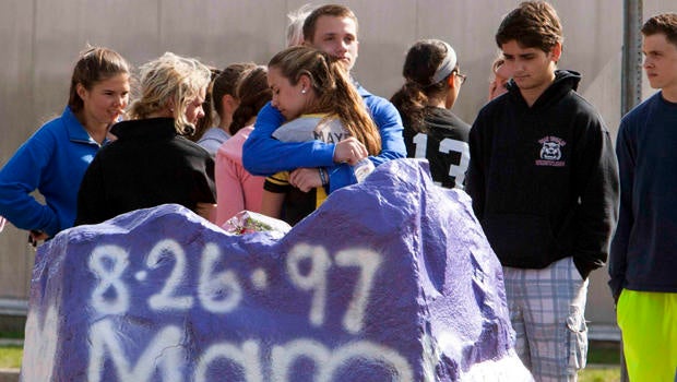 Students mourn in front of Jonathan Law High School in Milford, Connecticut, April 25, 2014. A 16-year-old girl was killed in an attack inside the school.