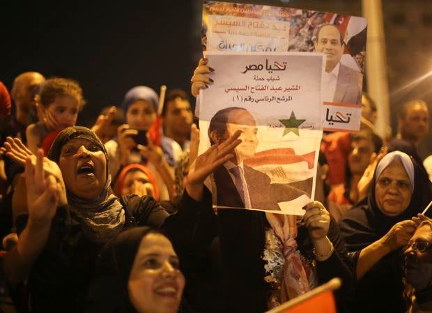 Supporters of Abdel-Fattah el-Sissi hold poster of him as they celebrate at Tahrir Square in Cairo on May 28, 2014