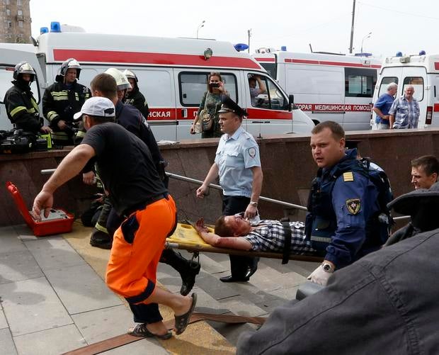 Members of the emergency services carry an injured passenger outside a metro station following an accident on the subway in Moscow July 15, 2014.
