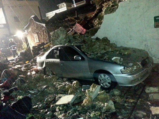 Seen in a raining downpour, a vehicle is covered in rubble from the wreckage from a Taiwan domestic airliner that crashed while attempting to land in stormy weather on the Taiwan island of Penghu July 23, 2014.