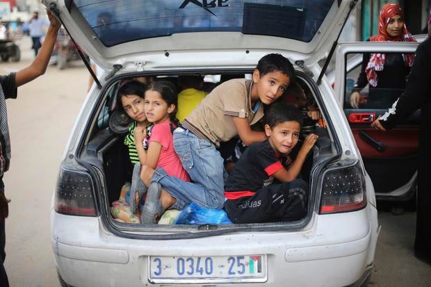 Palestinian children sit in car trunk as they flee their family homes following heavy Israeli shelling during Israeli ground offensive east of Khan Younis, in the southern Gaza Strip, on July 23, 2014