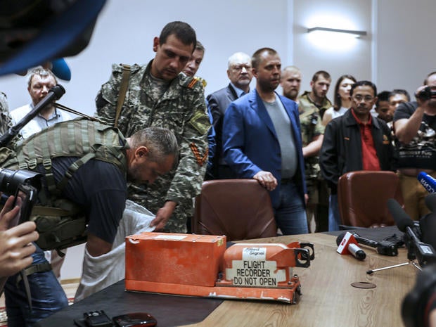 A pro-Russia separatist shows members of the media a black box belonging to Malaysia Airlines Flight 17 before handing it over to Malaysian representatives during a press conference in Donetsk, Ukraine, July 22, 2014.