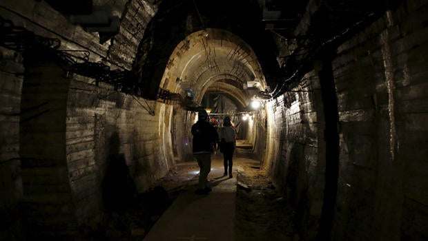 People walk through a tunnel, which is part of the Nazi Germany "Riese" construction project, under the Ksiaz castle in an area where a Nazi train is believed to be, in Walbrzych, Poland, Sept. 3, 2015.