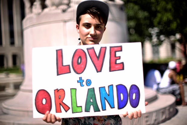 Ciaran Lithgow of Washington, D.C., holds a sign of condolence in Washington for victims of the attack on a gay nightclub in Orlando, Florida, on June 12, 2016.