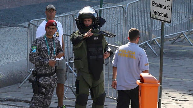 An agent of the bomb squad in protective clothing stands in the area near the finishing line of the men's cycling road race at the 2016 Rio Olympics after they made a controlled explosion, in Copacabana, Rio de Janeiro, Brazil, August 6, 2016.