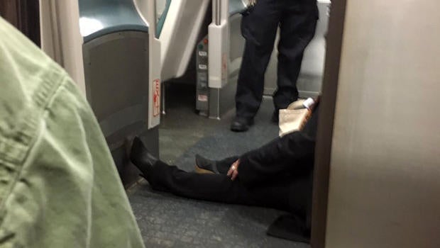 A commuter train passenger sits on the floor of a train car after a Long Island Rail Road train derailed at Atlantic Terminal in Brooklyn, N.Y., on Jan. 4, 2017.