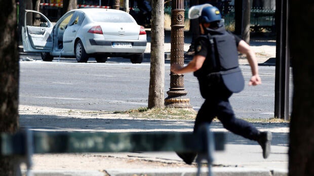 A French gendarme runs past a car on the Champs-Elysees after an incident in Paris, France, June 19, 2017.