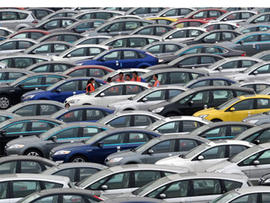 In this Aug. 25, 2010 photo, people stand near Ford cars at a plant of Changan Ford Mazda Automobile Co. in southwest China's Chongqing city.