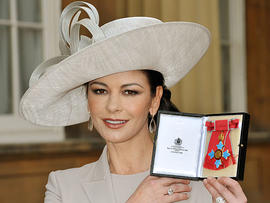 Catherine Zeta Jones poses for photographs after receiving her Commander of the Order of the British Empire (CBE) from Britain's Prince Charles at Buckingham Palace in London on Feb. 24, 2011.