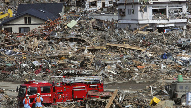Fire fighters search for survivors following the March 11 earthquake and tsunami in Rikuzentakata, Iwate prefecture, northeastern Japan, Friday, March 18, 2011.(AP Photo/Koji Sasahara)