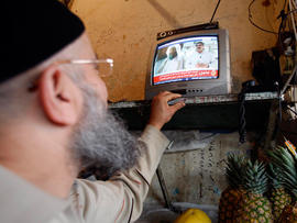 man watches a TV broadcast on the death of Osama bin Laden at a vegetable shop in the southern port city of Sidon, Lebanon