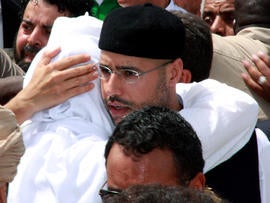 Seif al-Islam Qaddafi, son of embattled Libyan leader Muammar Qaddafi, embraces his brother Mohammad during the funeral of their brother Seif al-Arab Qaddafi at the Al-Hani cemetery in Tripoli, Libya, May 2, 2011, after the 29-year-old was killed along with three of the leader's grandchildren in a NATO airstrike May 1, 2011.