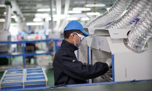 A worker at an Apple supplier facility in Chengdu, China, uses a laser etching machine.