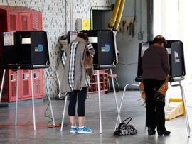 A pair of voters cast their ballots, Tuesday, Jan. 31, 2012, at a fire station in Coral Gables, Fla. Mitt Romney entered the day as the heavy favorite over Newt Gingrich in Florida's winner-take-all primary. Rick Santorum and Ron Paul have ceded the vote to the two front-runners and planned to spend the day campaigning in Colorado and Nevada.