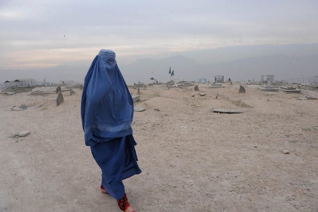 A burqa-clad Afghan woman walks in a cemetery Kabul on November 23, 2011.