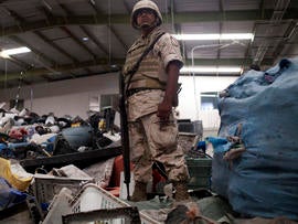 A Mexican army soldier stands inside a warehouse used for recycling assorted materials where an incomplete cross-border illegal tunnel was found underneath a bathroom sink by the Mexican army in Tijuana, Mexico, July 12, 2012.