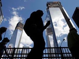 Visitors to the National September 11 Memorial walk below the rising towers 1 World Trade Center, left, and 4 World Trade Center, Monday, Sept. 10, 2012 in New York. Tuesday will mark the eleventh anniversary of the attacks of Sept. 11, 2001.