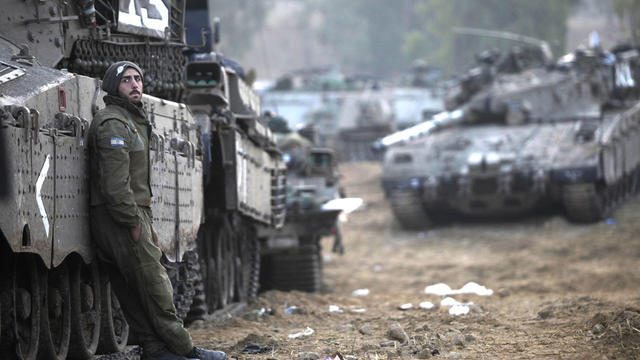 An Israeli soldier stands near tanks in a deployment area on November 19, 2012 on Israel's border with the Gaza Strip.  