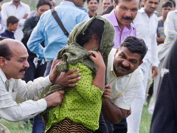 A young Christian girl accused of blasphemy is escorted to a helicopter after her release from prison