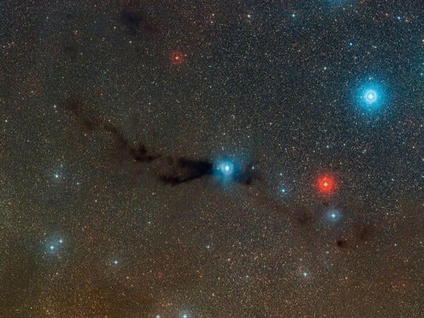 This wide-field view shows a dark cloud where new stars are forming along with cluster of brilliant stars that have already burst out of their dusty stellar nursery. This cloud is known as Lupus 3 and it lies about 600 light-years from Earth.