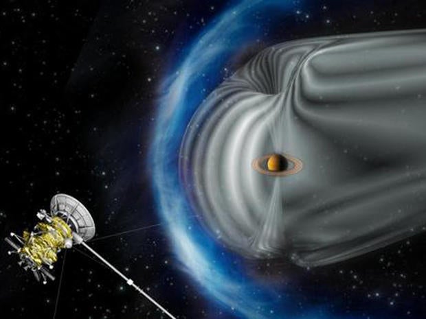 This artist's impression shows NASA's Cassini spacecraft exploring the magnetic environment of Saturn. Saturn's magnetosphere is depicted in grey, while the complex bow shock region â?? the shock wave in the solar wind that surrounds the magnetosphere â?? is shown in blue. The image is not to scale.