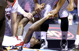 Louisville players talk to guard Kevin Ware after Ware's injury during the first half of the Midwest Regional final against Duke in the NCAA college basketball tournament, Sunday, March 31, 2013, in Indianapolis.