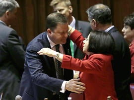 Senate Minority Leader John McKinney, R-Fairfield, who represents Newtown, Conn., left, is embraced by Conn. Sen. Toni Boucher, who represents western coast towns of Conn., after the passage of a gun-control bill in the Senate chamber at the Capitol in Hartford, Conn., Wednesday, April 3, 2013. The bill passed the Senate and goes onto the Conn. Houses for approval. Hundreds of gun rights advocates are gathering at the statehouse in Hartford ahead of a vote in the General Assembly on proposed gun-control legislation.