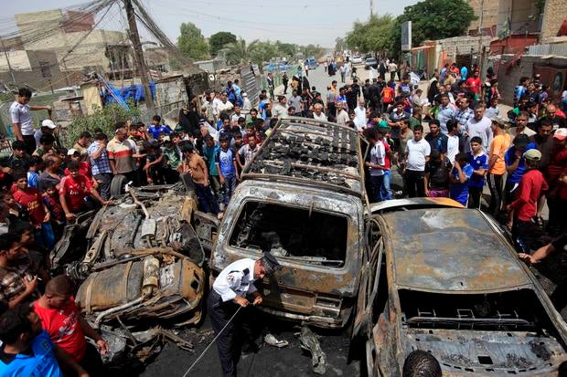 People gather at the scene of a car bomb attack in the Sadr City neighborhood in Baghdad