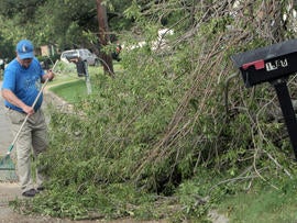 Don Graf cleans his property in Cleburne, Texas, May 17, 2013, two days after powerful storms produced 16 tornadoes in the area.