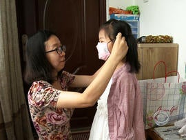 Mindy Wu makes sure her 5-year-old wears a mask to school.