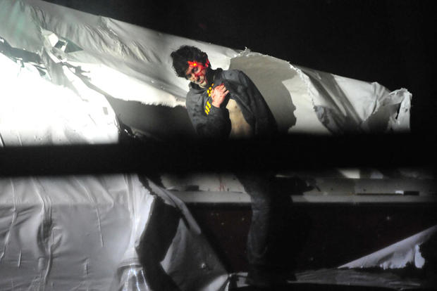 Dzhokhar Tsarnaev emerges from the boat he was hiding in in Watertown, Mass.