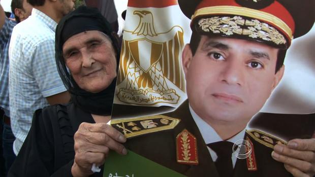 A woman holds a sign of Gen. Abdel Fattah al-Sisi's face. 