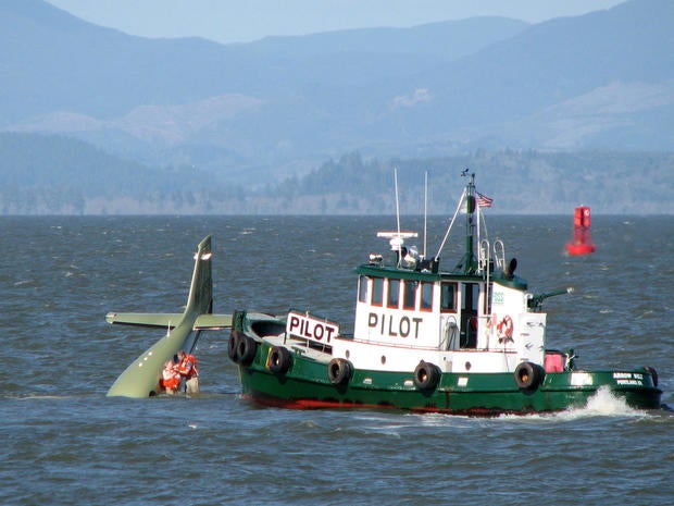 Bill Henningsgaard and his mother, Edith Henningsgaard-Miller, stand on the wing of his plane after it crashed into the Columbia River near Astoria, Ore., April 24, 2009, in this picture provided by Tapirback.com.
