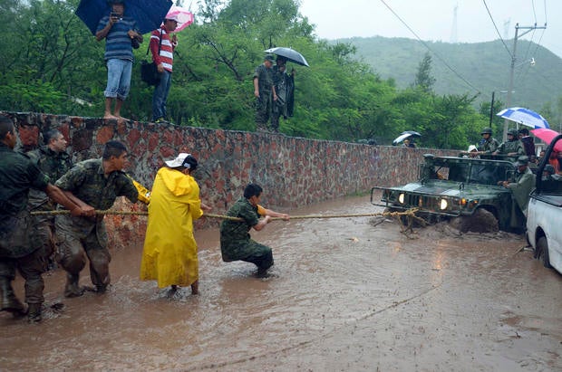 Army soldiers work to try to get their vehicle out of a flooded portion of a road caused by Tropical Storm Manuel in the city of Chilpancingo, Mexico, Sunday Sept. 15, 2013. In the southern Pacific Coast state of Guerrero, rains unleashed by Manuel resulted in the deaths of six people when their SUV lost control on a highway headed for the tourist resort of Acapulco. Another five people died in landslides in Guerrero and Puebla states, while the collapse of a fence killed another person in Acapulco.