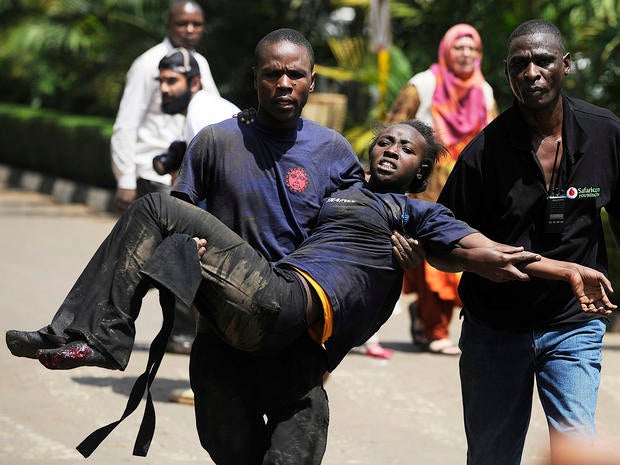 A Kenyan woman is helped to safety after masked gunmen stormed an upmarket mall and sprayed gunfire on shoppers and staff Sept. 21, 2013, in Nairobi, Kenya.