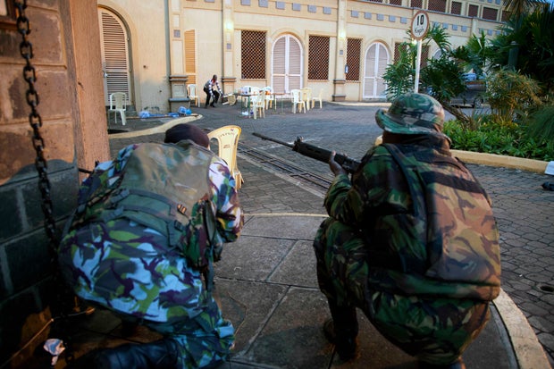 Kenya security personnel take cover outside the Westgate Mall