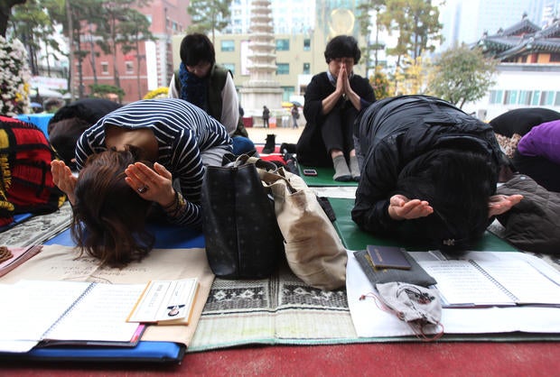Parents pray during a special service to wish for their children's success in the college entrance exam at the Jogye Temple in Seoul
