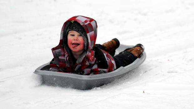 Matthew Mattei, 2, sleds backwards in Grosse Pointe Farms, Mich., Jan. 1, 2014. Michigan residents are facing a white and chilly New Year's Day, with snow falling in many parts of the Lower Peninsula and temperatures hovering around zero in parts of the U