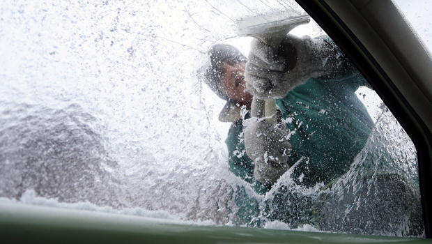 Terry Gillis scrapes ice off his car's window Feb. 12, 2014, in Fort Payne, Ala. 
